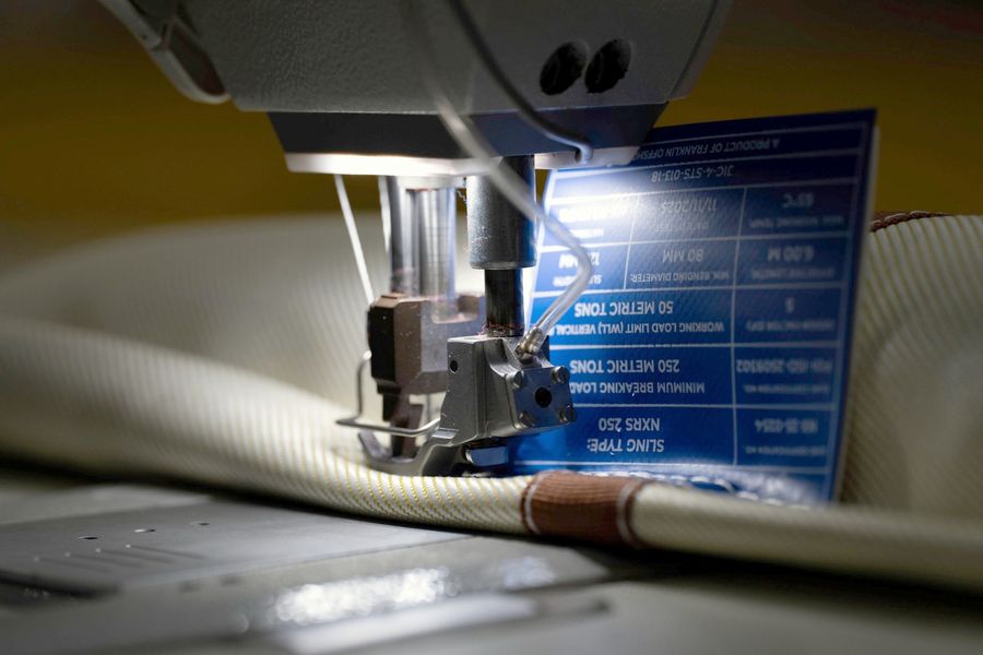 Identification tag being sewn onto a sling
