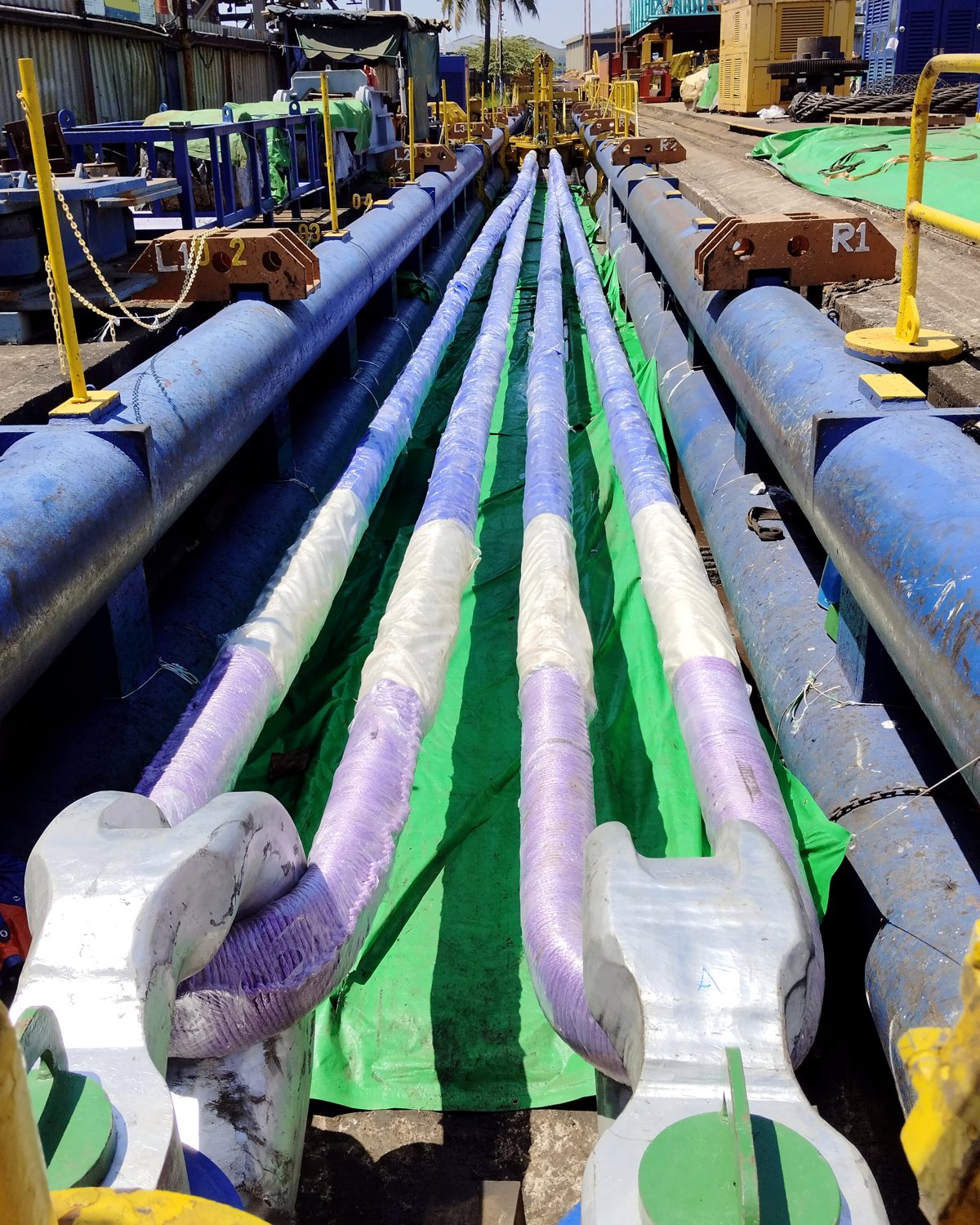 Two matched round slings on shackles laid out along a long horizontal test bed